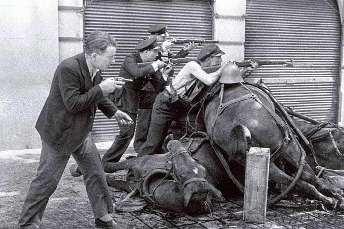 Men with guns over dead horses bodies